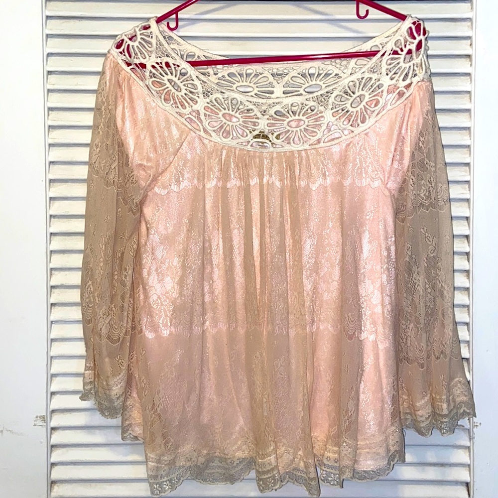 Pink and white lace blouse with 3/4 length sleeves.